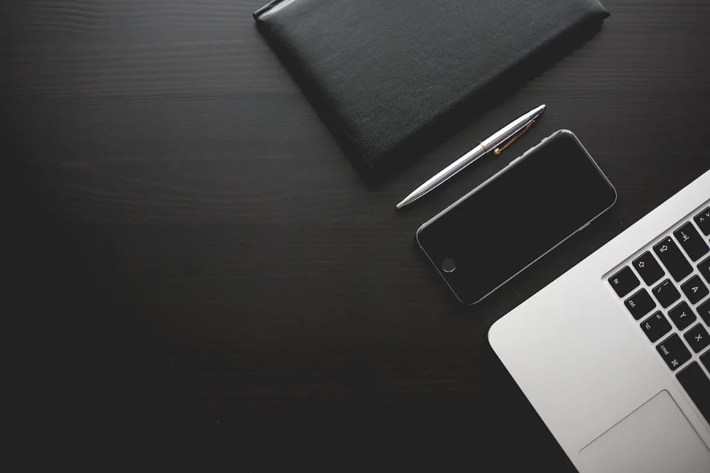 Fotografía ilustrativa de una mesa de trabajo con computadora y teléfono